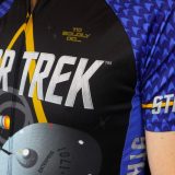 Closeup of a blue Star Trek cycling jersey featuring the Enterprise and delta logo, part of the fitness apparel line from Brainstorm Gear