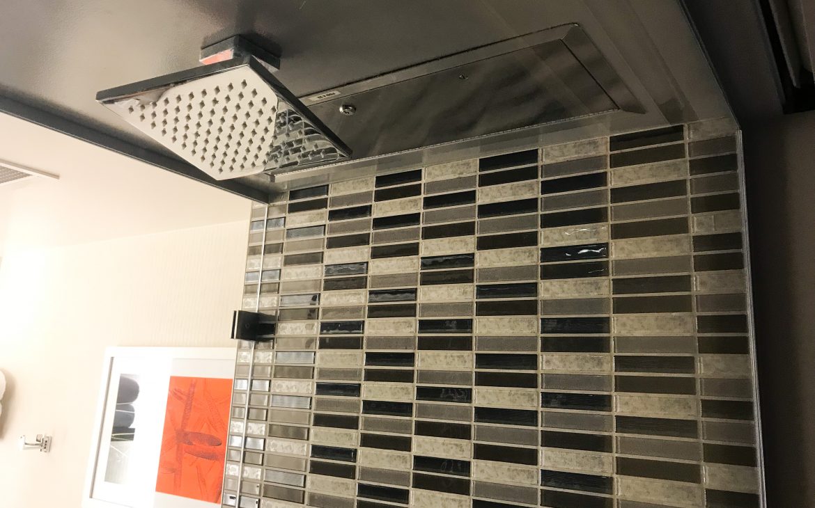 Tiled shower with rainfall showerhead at The Shore Hotel Santa Monica