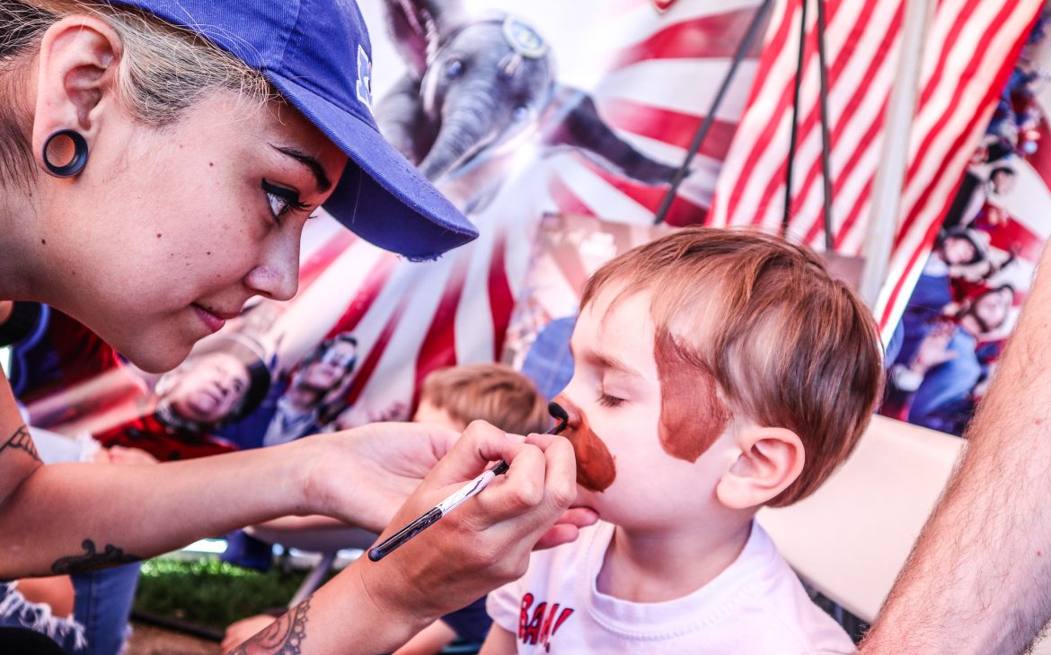 A little boy gets his face painted like a puppy at Disney's promotional booth for Dumbo