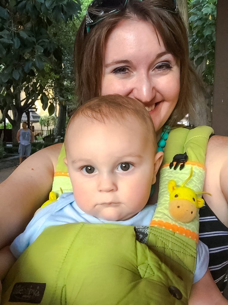 A chubby baby in a green Lillebaby Organic Complete carrier