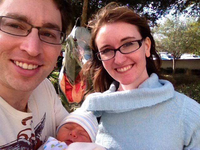 A happy couple holds a newborn baby they just adopted in Florida