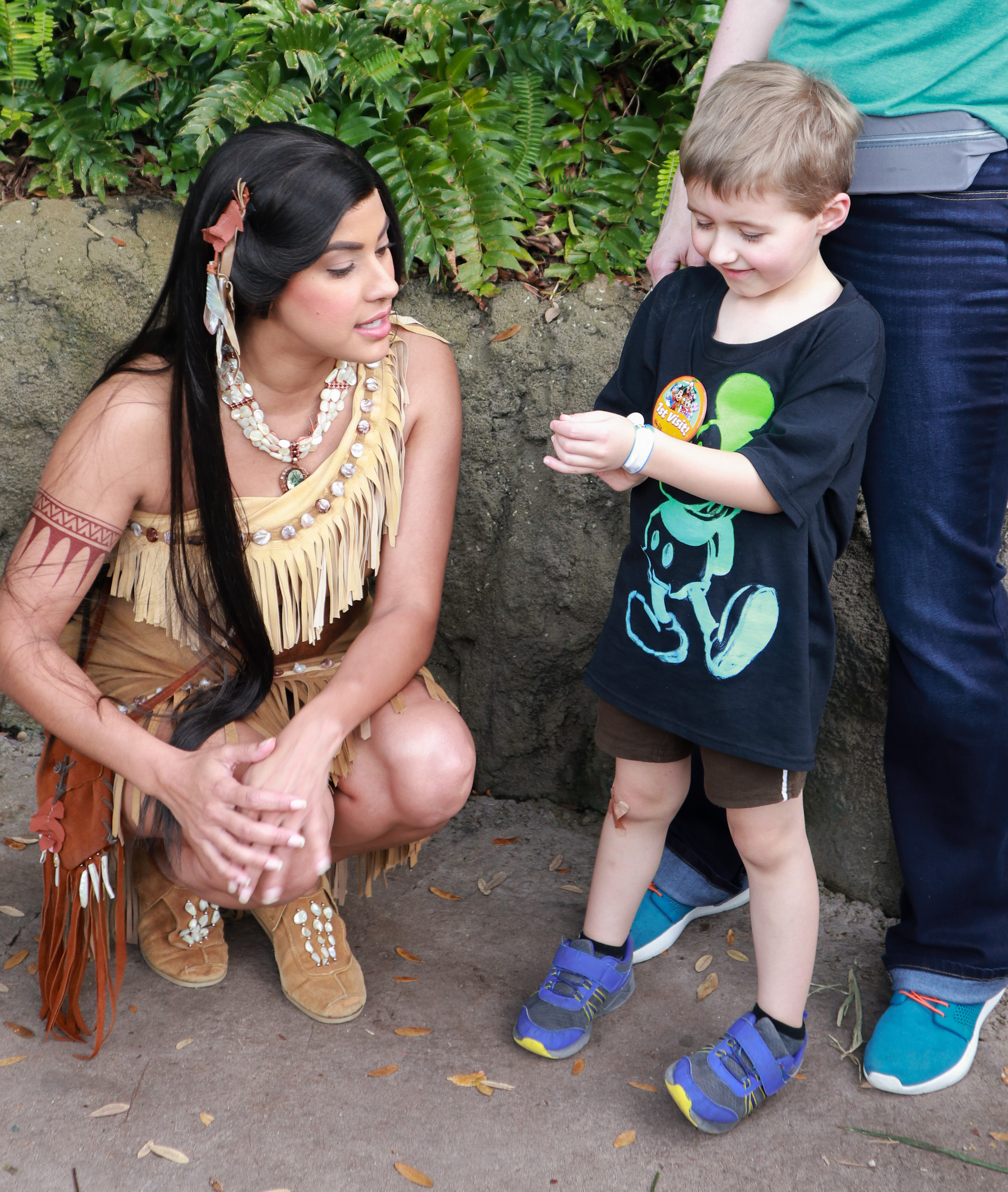 Pocahontas looks at a boy's ID bracelet