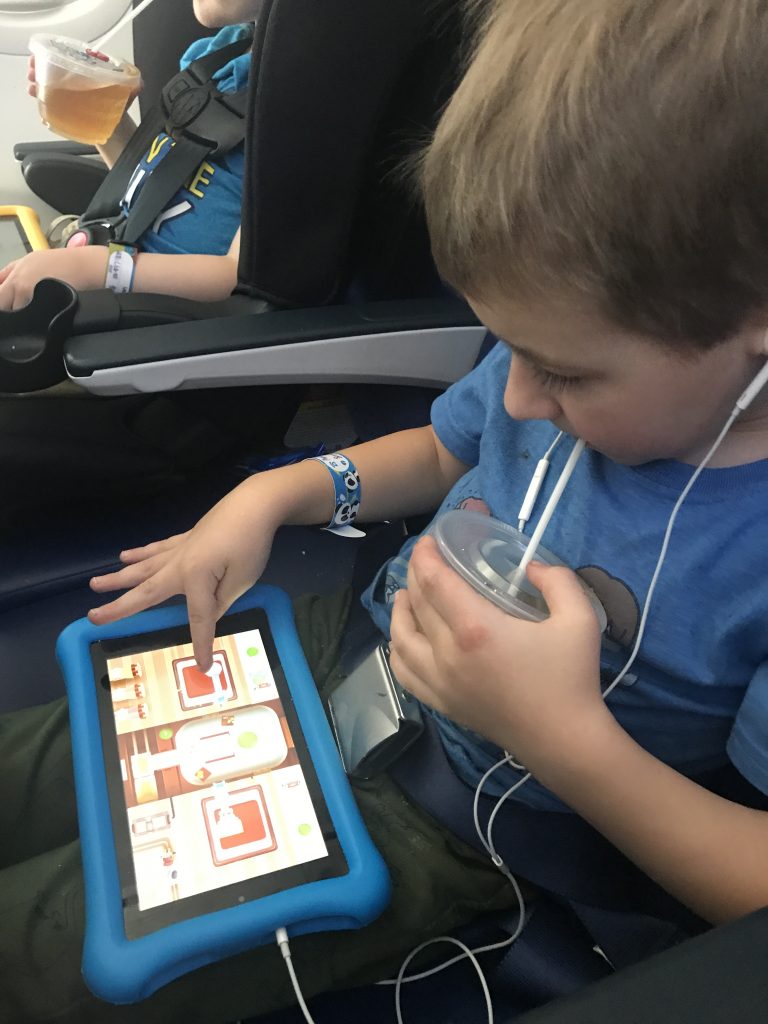 A boy plays with the Amazon Fire Tablet Kid Edition whle on an airplane