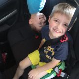 Smiling boys playing in the backseat of a car