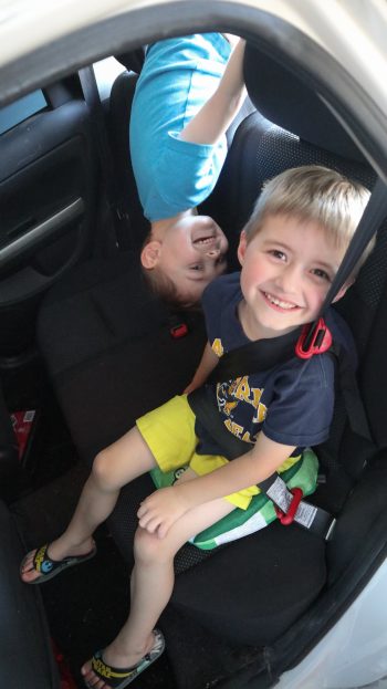 Smiling boys playing in the backseat of a car