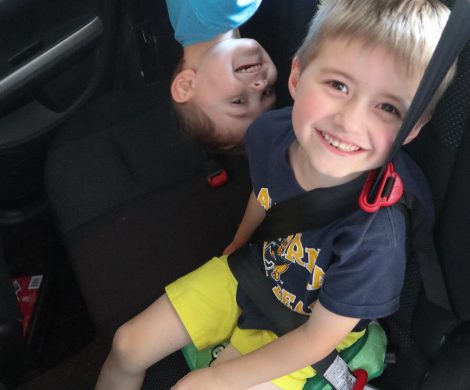 Smiling boys playing in the backseat of a car