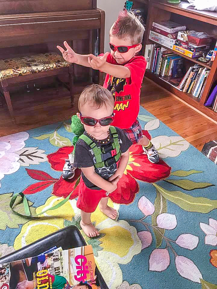 Two cute Morgan kids standing on a flower rug in front of a bookcase in an airbnb house.