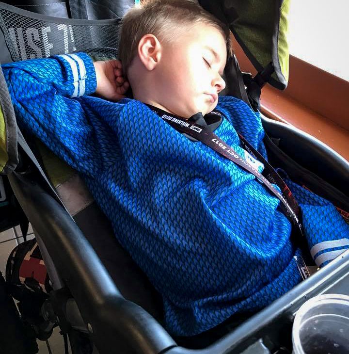 A little boy in a Spock Star Trek costume falls asleep in a stroller