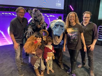 The Morgan family in the Dark Crystal: Age of Resistance cosplay as a Skeksis, Mystic, Rian and Hup, pictured with the Jim Henson Studios team