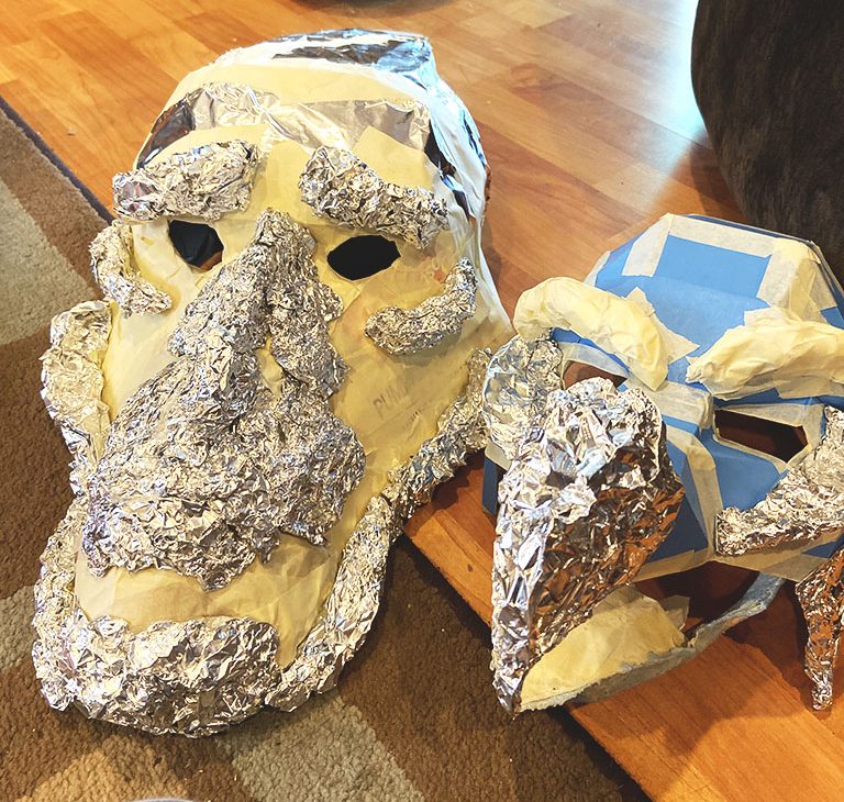 A Mystic and Skeksis mask from the Dark Crystal, made out of aluminum foil and cardboard